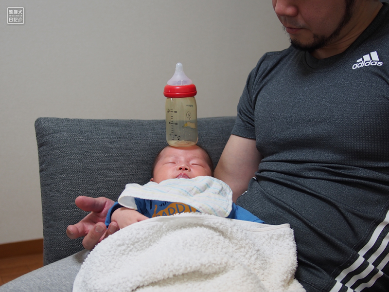 赤ん坊のおでこに哺乳瓶