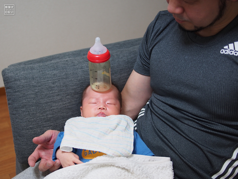 赤ん坊のおでこに哺乳瓶